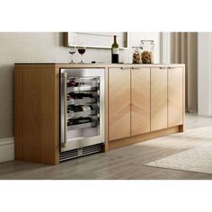 a wine cooler in the middle of a kitchen with wooden cabinetry and flooring