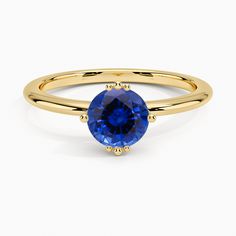 a yellow gold ring with an oval blue sapphire