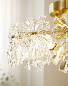 a chandelier hanging from the ceiling in a room with white walls and curtains