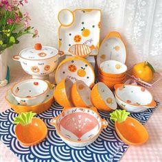 an assortment of orange and white dishes on a table