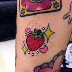 a person with a tattoo on their leg has a camera, strawberry and stars around it