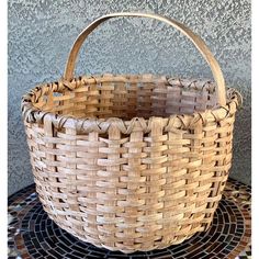 a woven basket sitting on top of a mosaic floor