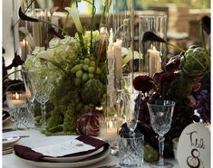 the table is set with candles, flowers, and wine glasses for an elegant dinner