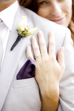 a person in a suit and tie with a flower on his lapel, holding onto the other hand