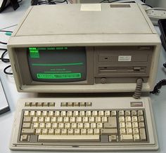 an old computer sitting on top of a desk next to a keyboard and mouse,