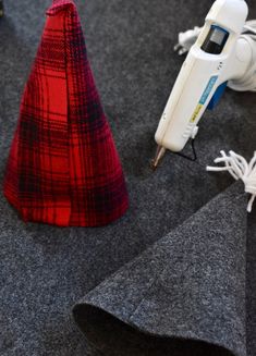 a red and black cone sitting on top of a floor next to a cordless hair dryer