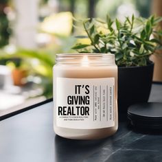 a candle sitting on top of a table next to a potted plant