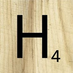 the letter h is made out of wood and has four black letters on top of it