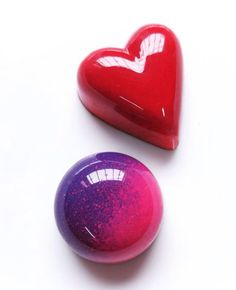 two heart shaped candys sitting next to each other on top of a white table