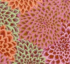 an orange, pink and green flower print fabric with a ruler on the side of it