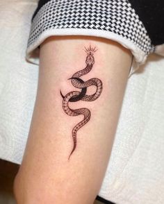 a woman's arm with a snake tattoo on it