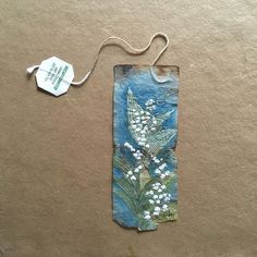 a piece of paper with white flowers on it and a tag attached to the side