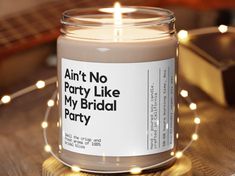 a candle that is sitting on a table with some lights around it and the words, ain't no party like my bridal party