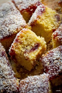 several pieces of cake are covered with powdered sugar and sprinkled with cranberry sauce