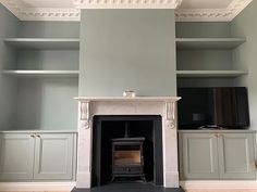 an empty room with a fireplace and built in shelves