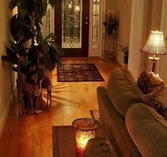 a living room filled with furniture and a lamp on top of a hard wood floor