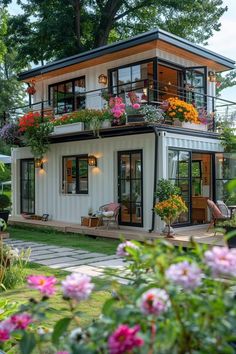 a small house with lots of flowers on the balcony