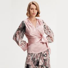 Cut from an acetate fabric mixed with a veil printed on the sleeves, this piece highlights the silhouette with elegance. V neckline and waist tightened by a belt. To wear at the office with formal pants or a pencil skirt or play the "total" look with our "Long chiffon skirt with ruffles floral print". Main fabric:  75% Acetate, 25% Polyester Sleeves: 100% Polyester Print fabric: 80% Viscose, 20% Nylon Machine wash gentle cycle (30 degrees max) Elegant V-neck Blouse With Sheer Sleeves, Fitted Silk Blouse With Draped Sleeves, Silk Evening Wrap Blouse, Silk Wrap Blouse For Evening, Elegant Pink Silk Blouse, Elegant Fitted Blouse With Elastic Sleeves, Fitted Silk Wrap Blouse, Fitted V-neck Blouse With Elastic Sleeves, Spring Evening Wrap Blouse