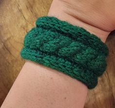 a person wearing a green knitted wristband