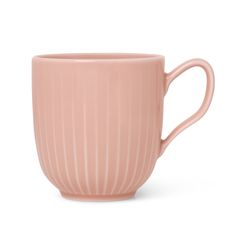 a pink coffee cup sitting on top of a white table