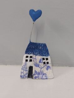 a blue and white house with a heart shaped balloon