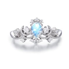 a white gold ring with an oval blue opal surrounded by small round diamonds on the sides