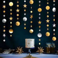 a table topped with a cake and stars hanging from it's ceiling next to bottles