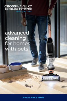 a man standing next to a window with a vacuum on the floor in front of him