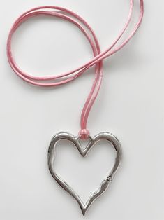 It's no surprise how this dreamy choker earned its name... You'll fall in love every time you look at it! Featuring the dreamiest pink satin cord and stunning statement-making heart pendant, the 'LOVE AT FIRST SIGHT' wrap choker is the necklace you've been waiting for. Trust us, compliments are waiting... Available in silver zinc alloy and 18K antique gold. Waterproof & rust-free. Made with genuine satin cord. 55" length - designed to allow you to tie this piece in multiple ways. Handmade with l Tying Cord Necklace, Hearts Necklaces, Heart Crystal Pendant Necklace, Heart Can Necklace, Can Tab Heart Necklace Tutorial, Handmade Pink Heart Necklace, Pink Adjustable Heart Necklace, Pink Heart-shaped Choker As A Gift, Metal Heart Pendant Choker