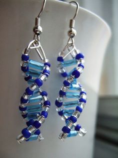 blue and silver beaded earrings sitting on top of a cup