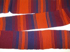 two red and blue striped ties laying next to each other on top of a white surface