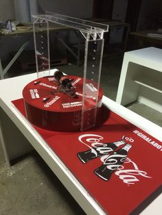 a coca - cola display case sitting on top of a table