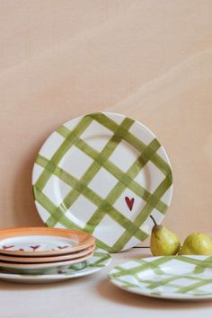 plates with pears on them sitting next to each other in front of a wall