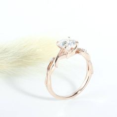 a close up of a ring with a feather on the side and a white background