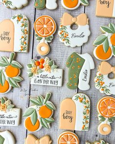 decorated cookies with oranges and green leaves are arranged on a wooden surface, including the names of each cookie