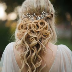 the back of a woman's head wearing a bridal hair comb with pearls