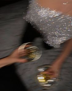 two people are holding wine glasses with sparkling bubbles on the top and bottom of them