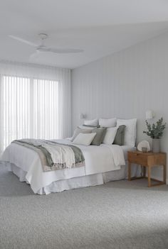 a bedroom with white walls and carpeted flooring