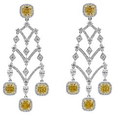 A well-crafted earrings showcasing eight cushion cut fancy yellow diamonds, set in a brilliant diamond halo in an Intricately designed chandelier style. Yellow Diamonds weigh 4.98 carats total; white diamonds weigh 4.41 carats total. Finely made in 18K white gold. Roman Malakov is a custom house, specializing in creating anything you can imagine. If you would like to receive a special quote on a custom piece please message or call us. Luxury Yellow Gold Sterling Silver Chandelier Earrings, Luxury Yellow Diamond Cut Earrings, Yellow Diamond Earrings With Diamond Accents For Wedding, Yellow Diamond Earrings With Accents For Wedding, Wedding Yellow Diamond Earrings With Accents, Luxury Yellow Diamond Earrings For Wedding, Formal Yellow Diamond Earrings With Diamond Cut, Yellow Diamond Earrings For Formal Occasions, Formal Yellow Diamond Cut Earrings