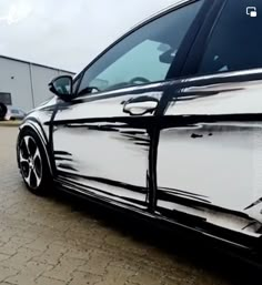 the side view of a white car parked in front of a building with its door open