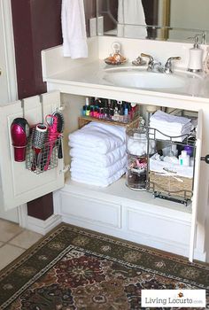 a white bathroom sink sitting under a mirror next to a pile of toilet paper and towels