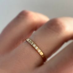 This narrow hammered band set with moissanites could be worn as a stacking ring or wedding band. Choose a color of gold, a number of moissanites, and a finish to customize your ring. Moissanite is a diamond alternative which is lab created. It's more brilliant and nearly as hard as diamond, but without the human and environmental impacts associated with mined stones. The band is hammered and the stones are bead set by hand. DETAILS - band is 2 mm wide and 1.7 mm thick - 1.5 mm moissanites - comf Minimalist Bands With Single Cut Diamonds For Anniversary, Minimalist Anniversary Bands With Single Cut Diamonds, Hammered Diamond Jewelry For Anniversary, Gold Hammered Stackable Rings For Promise, Wedding Hammered Diamond Jewelry, Elegant Hammered Stackable Promise Rings, Gold Stackable Rings With Rose Cut Diamonds, Elegant Hammered Diamond Rings, Yellow Gold Eternity Band With Rose Cut Diamonds