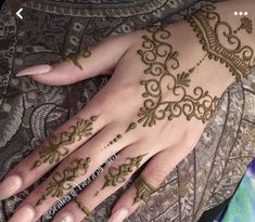 a woman's hand with henna tattoos on it