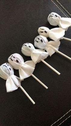 several marshmallows with faces on them are lined up in the shape of ghosts