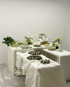 the table is covered with white cloths and flowers