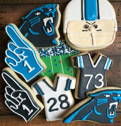 decorated cookies are arranged in the shape of football players and numbers on wooden boards with blue icing