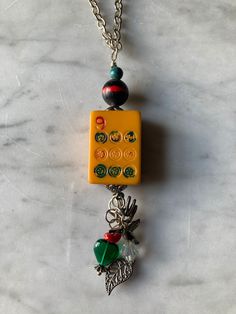 a yellow lego keychain with charms attached to it on a marble counter top