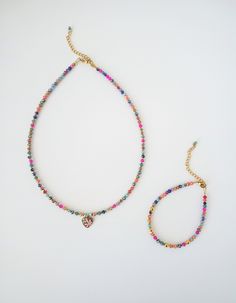 This exquisite choker necklace showcases a captivating blend of geometric patterns and vibrant hues. Crafted with a harmonious mix of gold accents, iridescent glass beads, and circular elements fromgold hematite, it exudes a luxurious and exclusive charm. Adorned with a heart pendant embellished with delicate floral motifs in soft turquoise and blush pink, this piece stands out as a truly unparalleled creation on the market. For those seeking to accentuate their facial features and illuminate th Multicolor Heart Beads Jewelry For Festival, Festival Multicolor Heart Beads Jewelry, Adjustable Multicolor Heart-shaped Jewelry, Adjustable Heart-shaped Multicolor Necklaces, Adjustable Heart-shaped Multicolor Necklace, Trendy Multicolor Jewelry With Heart Charm, Adjustable Multicolor Necklace With Heart Charm, Multicolor Heart Jewelry For Festivals, Multicolor Heart-shaped Jewelry For Festivals