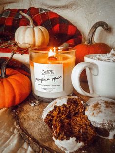 there is a candle and some pumpkins on the table next to eachother