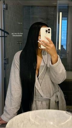 a woman taking a selfie in front of a bathroom mirror with her cell phone